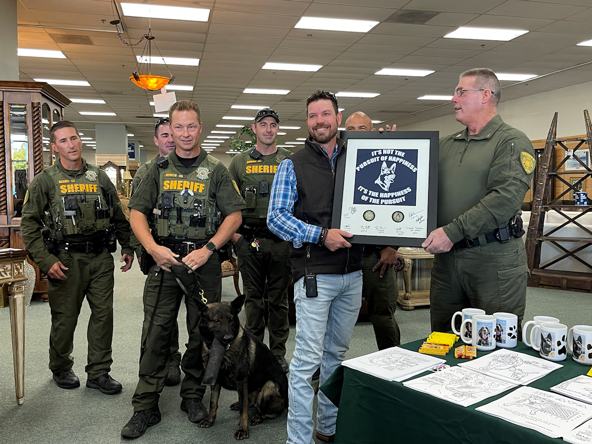 Photo of Washoe County Sheriff's Office Deputies presenting a thank you to Consign Furniture for their support over the past few years.